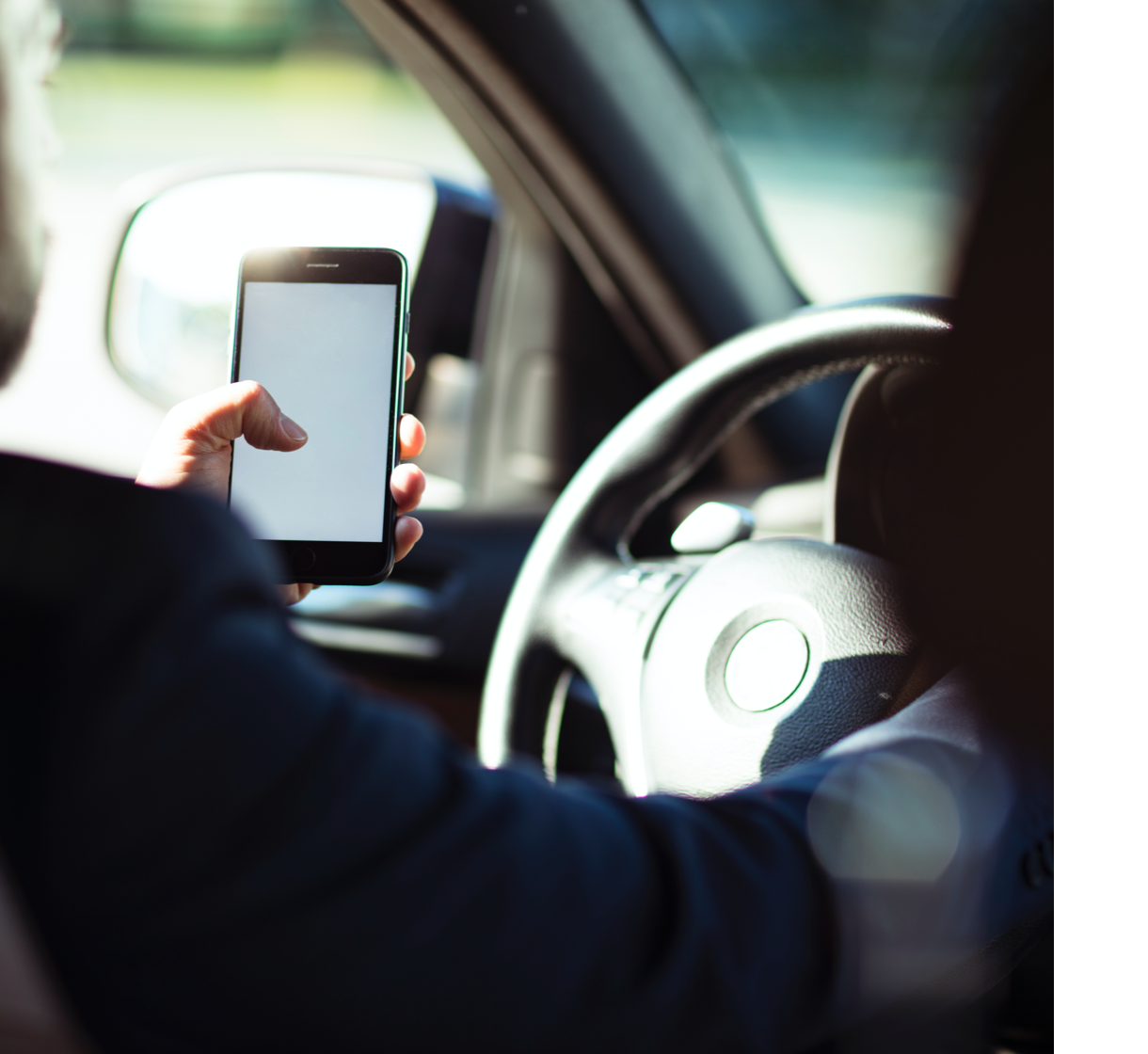 Persona al volante utilizza uno smartphone mentre guida