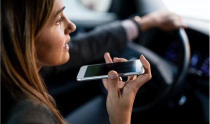 Il conducente utilizza uno smartphone per l'input vocale mentre è in auto