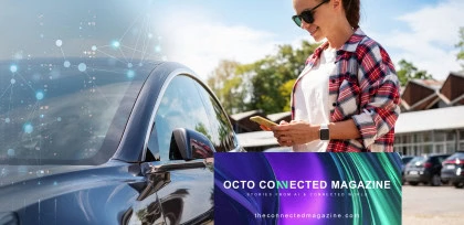 Donna sorridente usa lo smartphone accanto a un'auto moderna, con grafica digitale che richiama la connettività. In basso, il logo di Octo Connected Magazine e il sito theconnectedmagazine.com.