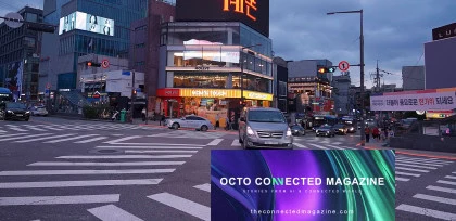 Urban intersection in Seoul at dusk, with busy traffic, wide crosswalks, illuminated commercial buildings and neon signs, reflecting a dynamic and connected city.
